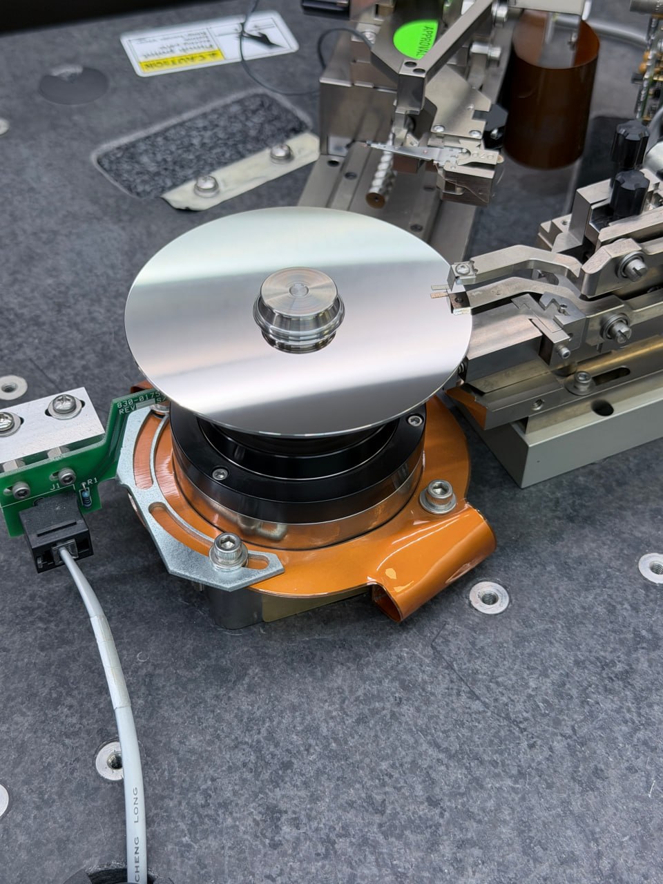 Hard drive platters mounted on burnishing machine spindle for contamination cleaning — Five Star Data Recovery Glendale CA